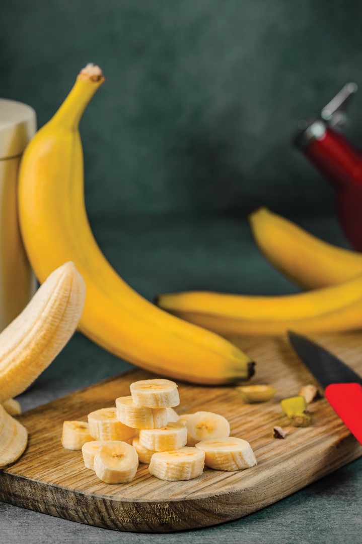 photo of whole and sliced bananas on a cutting board